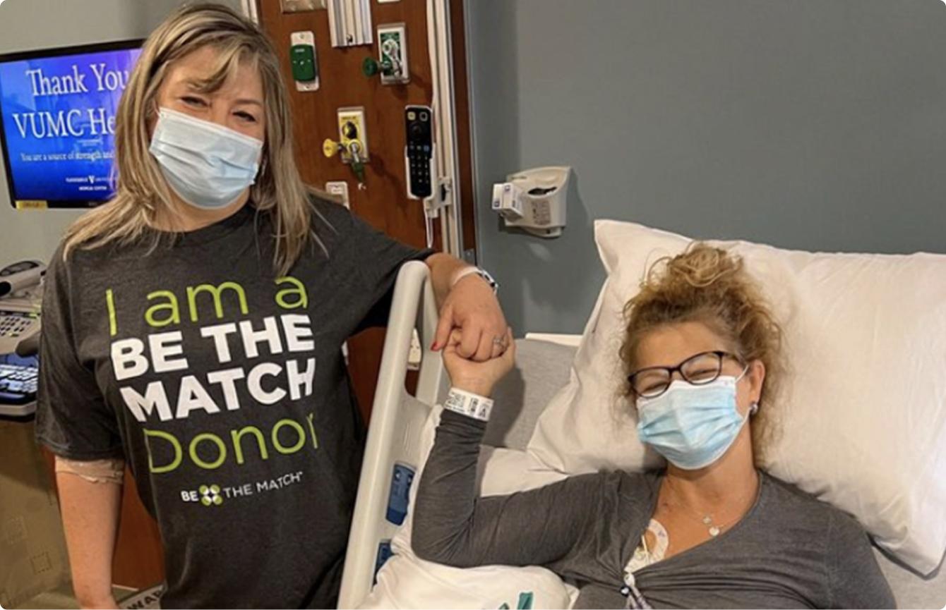 a woman in a hospital bed holding the hand of her sister standing next to her