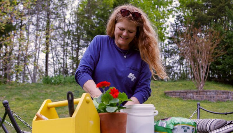 A video thumbnail of a female myelofibrosis patient in a blue shirt gardening in a yard.