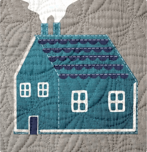 An embroidered home on a quilt square